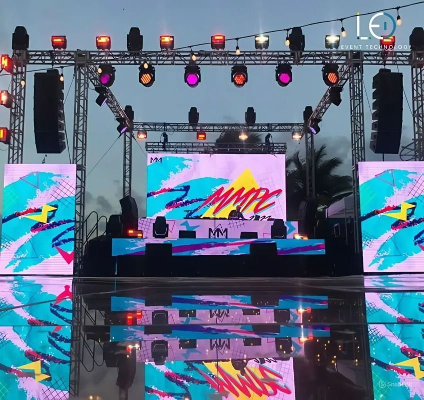 Palco com painéis de LED, treliças e iluminação profissional em evento ao ar livre