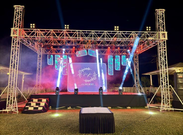 Palco noturno com treliças, painel de LED e feixes de luz