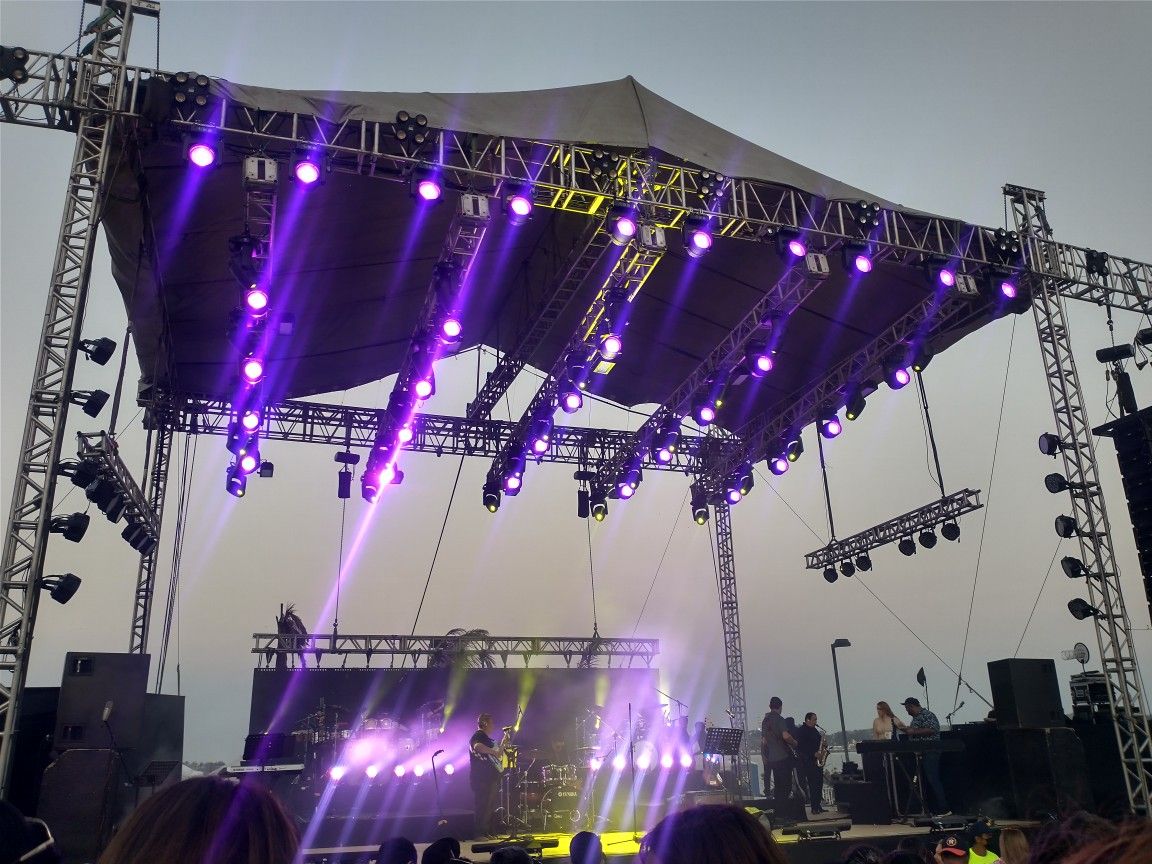 Grande estrutura de palco com iluminação profissional durante show ao vivo