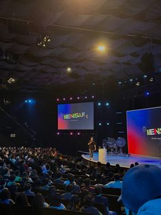 Palco com painéis de LED e iluminação cênica diante de plateia lotada